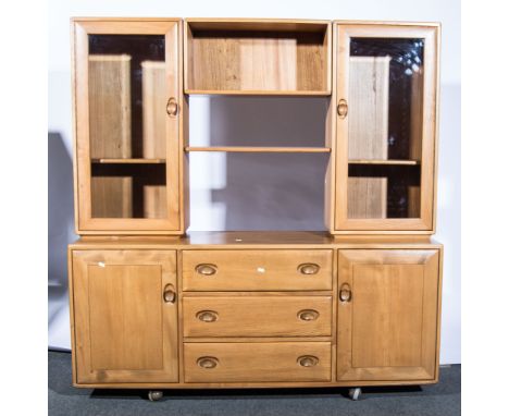 Lucian Ercolani for Ercol, a elm sideboard, shape 455, with two glazed cupboards flanking an open recess and adjustable shelf