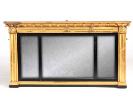 A REGENCY GILT GESSO OVER MANTEL MIRROR with moulded cornice and ribbon tied side columns with lions head corners, ebony reed