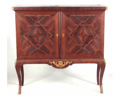 A 19TH CENTURY FRENCH CROSSBANDED AND QUARTER VENEERED ORMOLU MOUNTED ROSEWOOD SIDE CABINET the overhanging top above a pair 