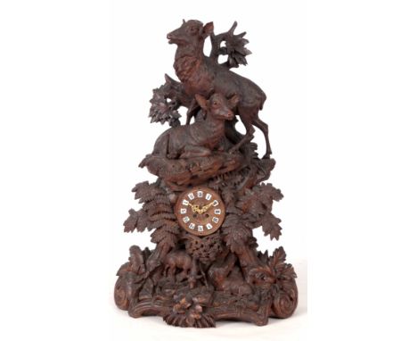 A MONUMENTAL 19th CENTURY BLACK FOREST CARVED TABLE CLOCK the case sumounted by a Stag and Hind with amber glass eyes on natu