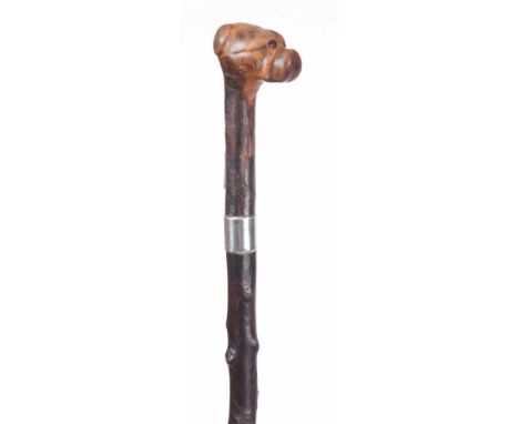 AN EARLY 20th CENTURY SILVER MOUNTED WALKING STICK WITH CARVED BULLDOG HANDLE having a blackthorn shaft with continental mark