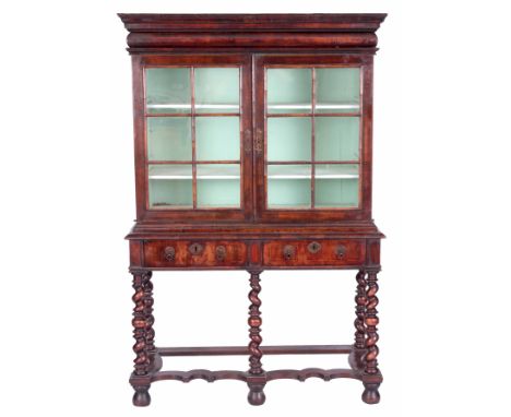 A WILLIAM AND MARY WALNUT CABINET ON STAND with glazed hinged doors and cushion moulded frieze, the interior is fitted with p