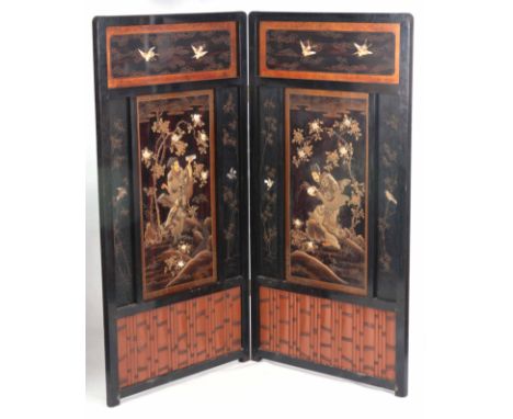 A MEIJI PERIOD JAPANESE LACQUERED AND SHIBAYAMA TWO FOLD SCREEN opening to reveal two panels depicting two figures in a garde