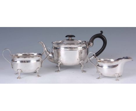 A GEORGE V THREE PIECE SILVER TEA SERVICE of oval design with shaped top edges, raised of short cabriole legs by J. Heath & J