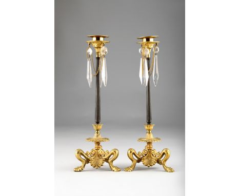 Pair 19th Century bronze and ormolu lustre candlesticks, with tear drop crystal prisms, bronze columns on ormolu tripod bases