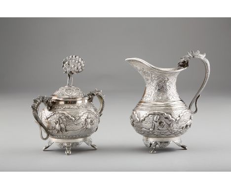 19th / 20th Century Burmese silver sugar basin and cover and a matching cream jug. Both decorated with figures and Acanthus s