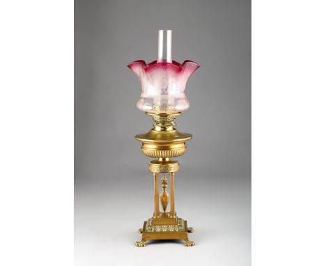 Victorian paraffin oil table lamp, heavy base with four corinthian columns with etched cranberry glass shade. 66cm high
