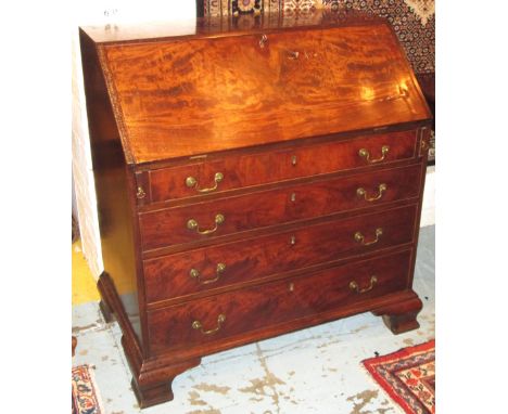 BUREAU, George III mahogany with a fall front enclosing a fitted interior over four graduated long drawers on ogee bracket fe