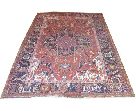 ANTIQUE NORTH WEST PERSIAN HERIZ CARPET, 345cm x 252cm, Serapi design of flower heads and vines on a terracotta field within 