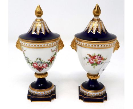 Pair of miniature Royal Worcester covered urns, H: 13 cm, small chip to cover of one urn and crazing on both, paint appears i