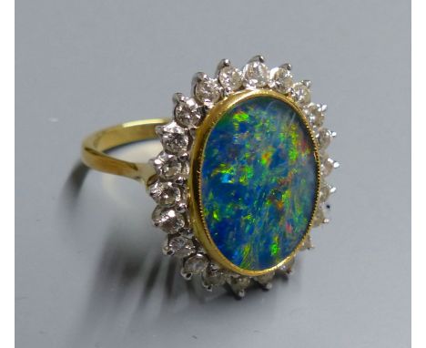 An 18ct, black opal doublet and diamond set oval cluster ring, size M, gross 7.3 grams.CONDITION: A few very minor scratches 