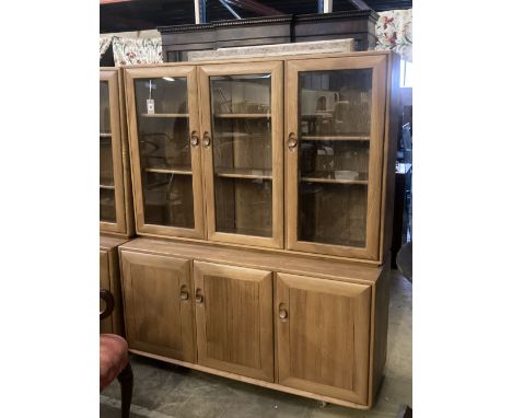 An Ercol display cabinet fitted three glazed panelled doors over cupboards, width 136cm depth 44cm height 162cm