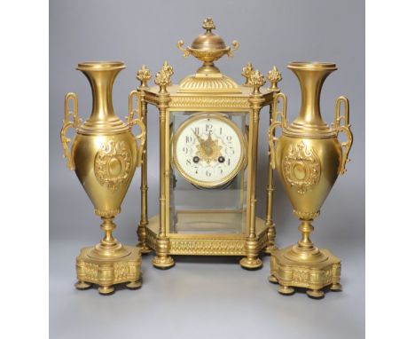 A late 19th century French garniture de cheminée comprising a four-glass mantel clock and a pair of vases
