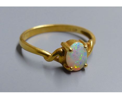 An 18k and single stone white opal ring, size O, gross 2.5 grams.CONDITION: Some minor surface scratches to the metal, consis