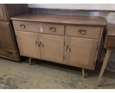 An Ercol elm sideboard (model no. 351), fitted one long drawer and one short drawer over three panelled doors, width 120cm de