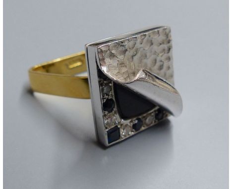 An unusual white metal, black onyx?, sapphire and diamond set square cluster ring, with planished 'peeled back' finish, on a 