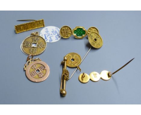 Eight assorted Chinese yellow metal amulets, four in the form of brooches, three pendants and a stick pin, 21.5 grams.CONDITI