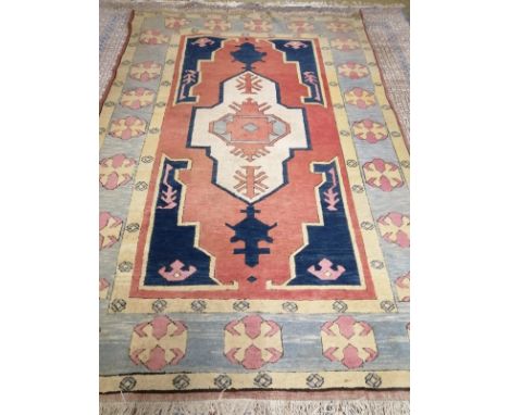 An Afghan Kazak rug, the red and blue ground field centred by an ivory cruciform medallion, woven silk and wool (Mayfair Carp