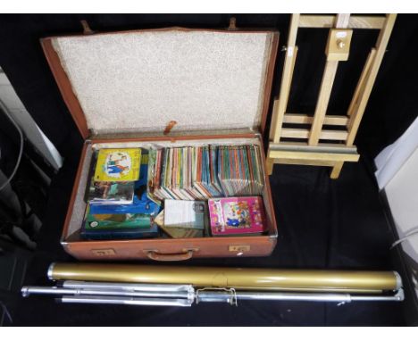 A vintage suitcase containing a quantity of Ladybird Books and other childrens books and puzzles, together with a artists eas