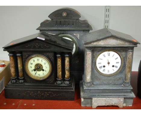 A late Victorian black slate mantel clock of architectural form having enamelled dial with Arabic numerals and eight day cyli