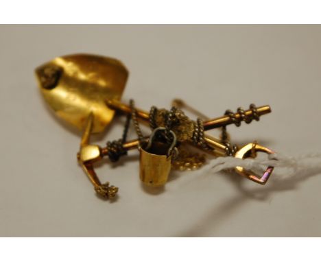 A yellow metal brooch modelled as a South African gold prospectors axe and shovel, apparently unmarked, 5.3g Condition Report