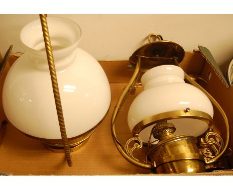 An early 20th century brass hanging oil lamp, having opalescent glass shade; together with one other similar hanging lamp; an