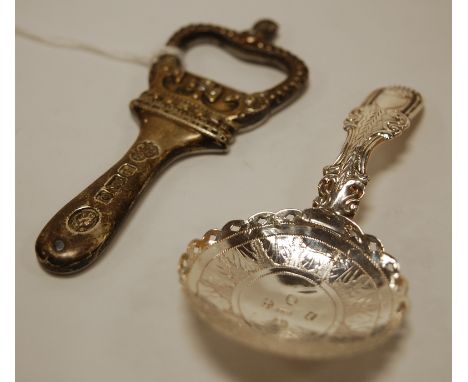 A reproduction commemorative silver mounted bottle opener, together with a circa 1830s silver and engraved caddy spoon (2)