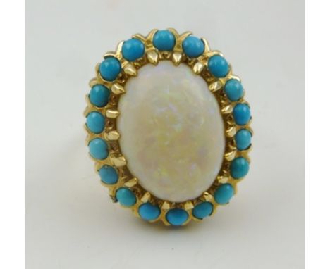 AN OPAL SET LADY'S RING, the central oval stone surrounded by eighteen turquoise stones, set in 14k claw mount and band, size