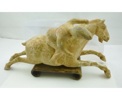 A TANG STYLE CERAMIC EQUESTRIAN FIGURE "Polo Player", resting upon a wooden plinth, 40cm long x 20.5cm high 