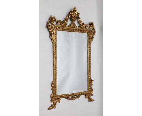 A GEORGE II DESIGN GILT FRAMED WALL MIRROR, having ornate urn floral crest flanked by cornucopia, with stylised dolphins to t