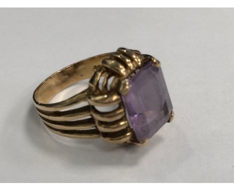 GEM SET RING, the step cut purple gem 12mm long, within an openwork setting, in nine carat gold, size Q, 5.6g