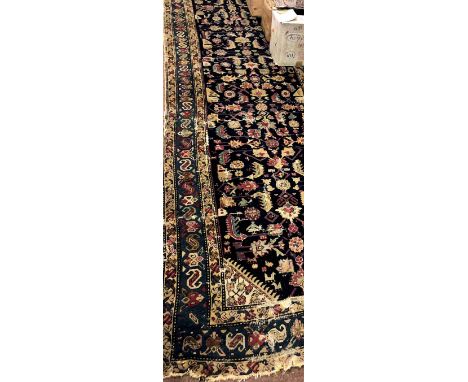 A large antique Oriental Runner, the dark blue ground centre with multiple designs, inside a light blue and other borders, ap