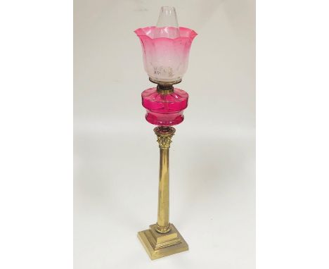 A tall antique brass Corinthian style Table Lamp, with crimson glass bowl, plain glass globe, and two matching tinted glass s