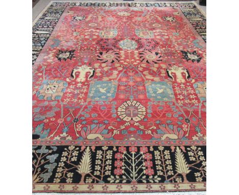 A fine quality Persian 20th Century claret ground Carpet, with a large floral decorated centre, and long black similarly deco