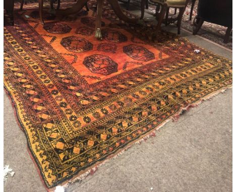 An unusual late 19th Century / early 20th Century Middle Eastern orange ground woollen Carpet, the rectangular centre with ei