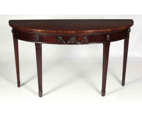A fine quality 19th Century mahogany demi-lune Console Table, the plain D shaped top over a decorated frieze with carved oval