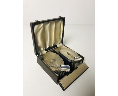 A cased pair of silver Brushes, together with a silver crested Caddy Spoon and another Celtic design Caddy Spoon. (4)