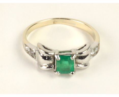 An attractive 18ct gold Ring, with central emerald type stone flanked by four small white diamond stones. (1)