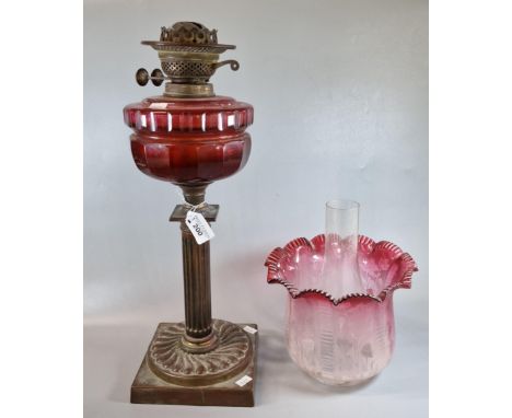 Early 20th century double oil burner lamp, having frosted cranberry shade with organic decoration above a cranberry glass res