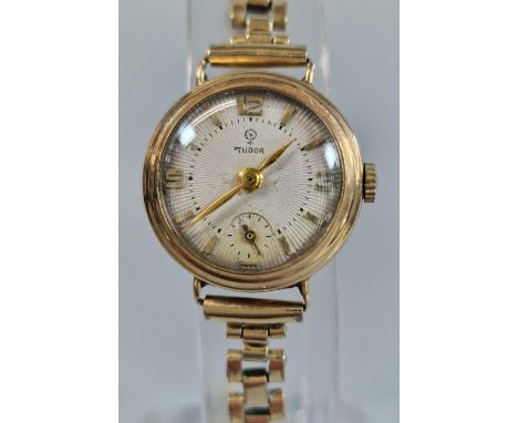 Lady's 9ct gold Tudor small head cocktail watch with satin face, Baton numerals and seconds dial on a gold plated bracelet st