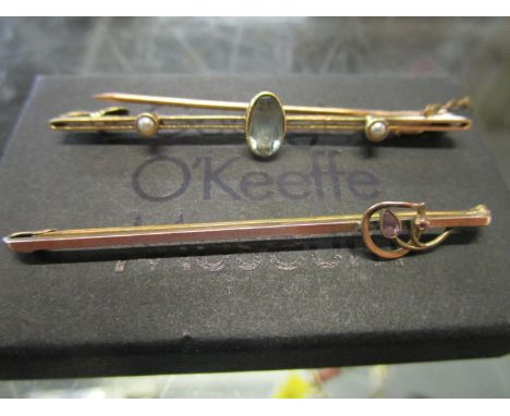 An Edwardian 15ct gold aquamarine and split seed pearl bar brooch on safety chain, and a 9ct gold Edwardian and amethyst set 