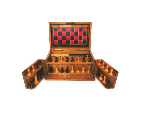 An early 20th Century oak cased games compendium with boxwood and ebony chess pieces (king 2.5” high), cribbage, draughts / b