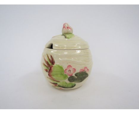 A Clarice Cliff Newport pottery lidded preserve jar in the Waterlily design, 11cm tall 