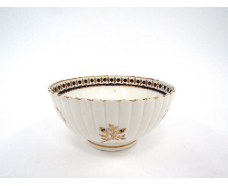 A George III Caughley porcelain slop bowl, fluted body with underglazed blue flowers, heightened with gilt, 15cm diameter, 7.