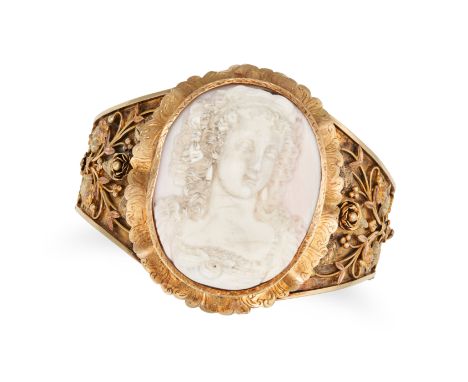 AN ANTIQUE CONCH SHELL CAMEO BANGLE in yellow gold, set with an oval conch shell cameo carved to depict the bust of a classic