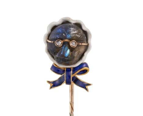 A LABRADORITE, DIAMOND AND ENAMEL MONKEY NOVELTY STICK PIN designed as a monkey in spectacles wearing a bonnet with a bow, th