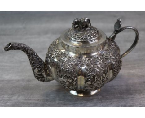 White metal Indian teapot of melon shape form, heavy repousse decoration to include animals, Elders, farmers amongst foliate 