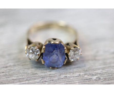 Sapphire and diamond three stone 9ct yellow gold ring, the large central oval mixed cut cornflower blue sapphire measuring ap