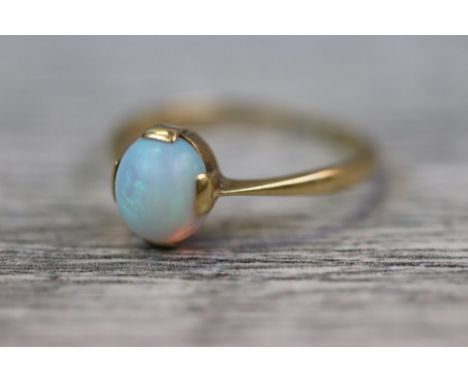 Opal 18ct yellow gold ring, the precious white opal cabochon measuring approximately 7mm x 6mm, four claw setting, displaying