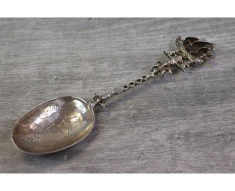 Silver presentation table spoon, the finial formed of a ship held by cherubs, openwork twisted stem, the bowl with engraved i